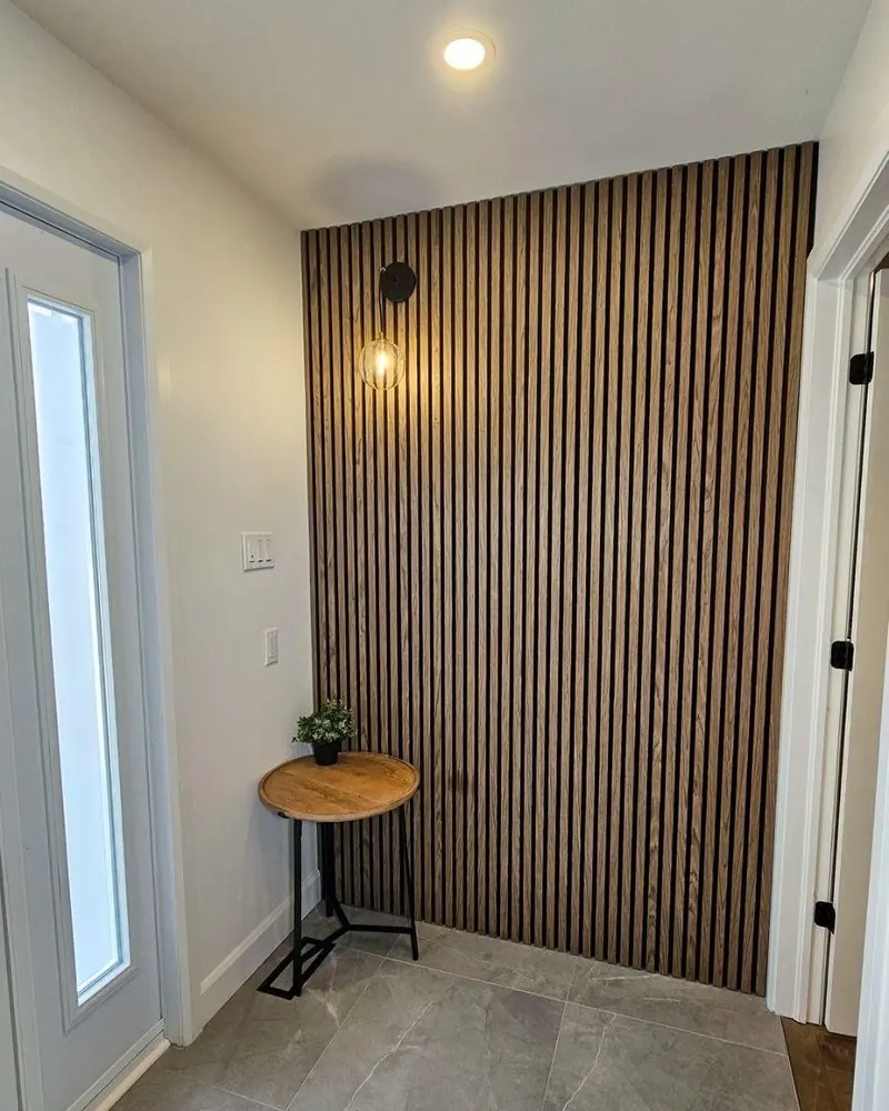 Mur décoratif de lattes de bois foncé dans une entrée