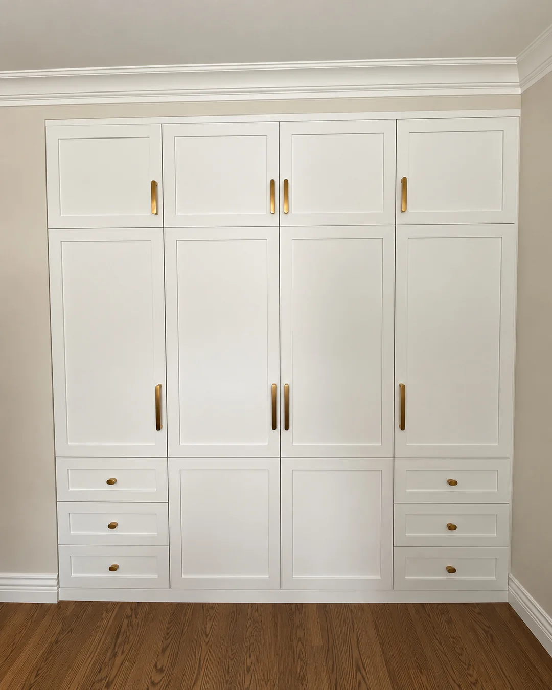 Garde-robe intégrée sur mesure, portes blanches et poignées en bois