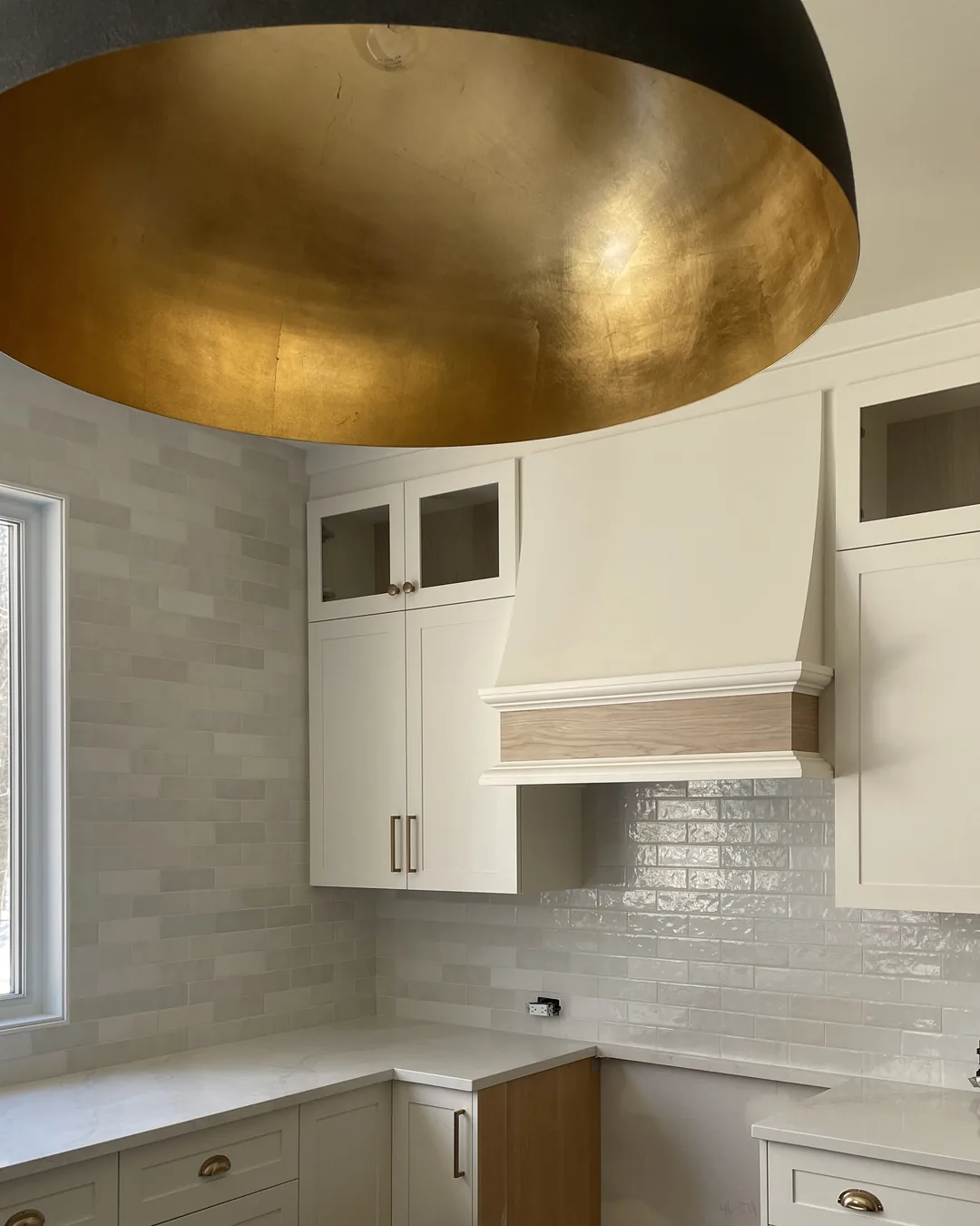 Une cuisine aux luminaires dorés · Sévigny Boucher